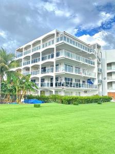 a large white building with a lawn in front of it at Lux Maho Reef Suite next to The Morgan Resort in Maho Reef