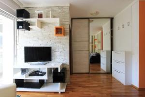 ein Wohnzimmer mit einem TV auf einem weißen Tisch in der Unterkunft Studio apartment in the centre of Budva in Budva