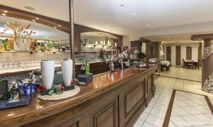 a bar in a hotel with a man behind the counter at Hotel Bussana in Porto Tolle