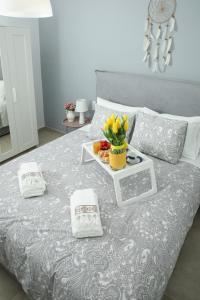 ein Bett mit einem Tablett mit Blumen darüber in der Unterkunft Chic & Spacious House in Rodia Heraklion in Iraklio