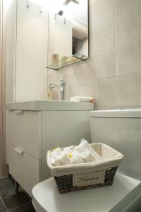 ein Bad mit einem Korb auf einem WC in der Unterkunft Chic & Spacious House in Rodia Heraklion in Iraklio