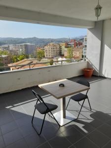 een tafel en 2 stoelen op een balkon met uitzicht bij jolly casa 2 in Cosenza