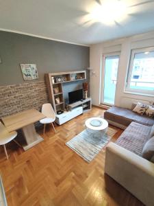 uma sala de estar com um sofá e uma mesa em Nota Home em Novi Sad
