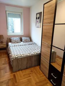 um pequeno quarto com uma cama e uma janela em Nota Home em Novi Sad