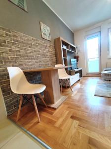 uma sala de estar com uma parede de tijolos e uma mesa e cadeiras em Nota Home em Novi Sad