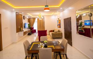 a dining room and living room with a table and chairs at Naya's Apartment: Luxurious Feel (Katampe, Abuja) in Abuja