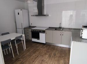 uma cozinha com electrodomésticos brancos, uma mesa e um frigorífico em Casa Independiente Centro em Águilas