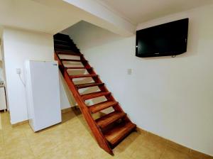 Una escalera en una habitación con TV en la pared en Centro RG en Río Gallegos