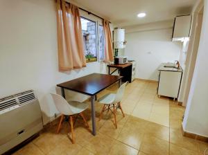 - une cuisine avec une table et des chaises dans la chambre dans l'établissement Centro RG, à Río Gallegos