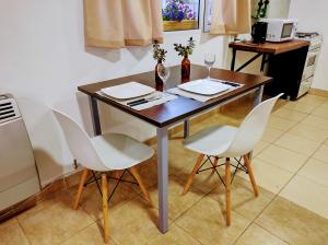 a table with two wine glasses and two chairs at Centro RG in Río Gallegos