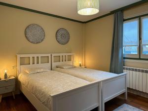 sypialnia z łóżkiem i 2 lustrami na ścianie w obiekcie Apartamento Axpelarru w mieście Ochandiano