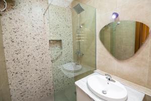 a bathroom with a sink and a glass shower at Naya's Apartment: Luxurious Feel (Katampe, Abuja) in Abuja +12 photos