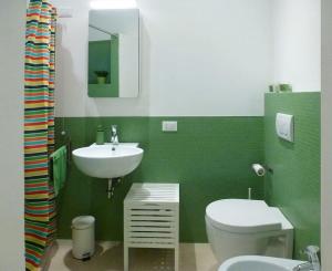 een groene badkamer met een toilet en een wastafel bij Dimora d'Artista in Ragusa