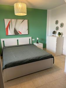 1 dormitorio con cama y pared verde en Il Paradiso Esiste, en Costa Calma