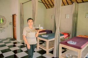 Eine Frau, die ein Tablett mit Essen in einem Zimmer hält. in der Unterkunft Sun Colada Villas & Spa in Nusa Penida