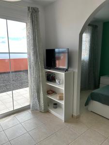 Habitación con TV, cama y ventana. en Il Paradiso Esiste, en Costa Calma