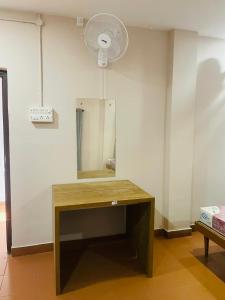 een kamer met een bureau met een spiegel en een ventilator bij Azhar lodge koyilandy in Kozhikode