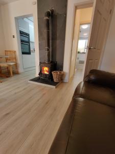 a living room with a wood burning stove in it at Owl's Watch in Ruthin