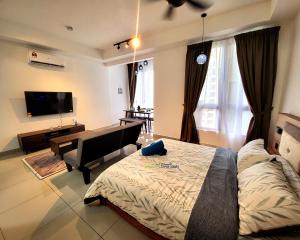 a living room with a bed and a television at Bali Residence Impian Raudah in Melaka