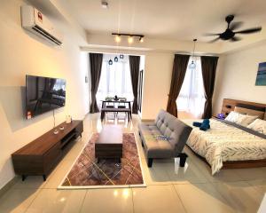 a large living room with a couch and a tv at Bali Residence Impian Raudah in Melaka