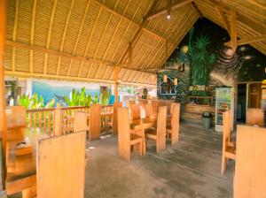 um restaurante com mesas e cadeiras de madeira numa sala em Lempeh Jungle Cottage em Nusa Penida