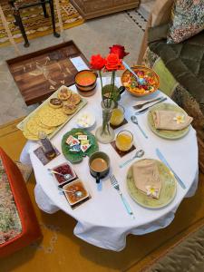 - une table avec des assiettes de nourriture et des fleurs dans l'établissement Riad Al Ibtikar, à Marrakech