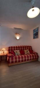 ein Wohnzimmer mit einer roten Couch in einem Zimmer in der Unterkunft Combe Blanche 1217 in Manigod