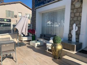 a patio with a couch and a vase with a plant at La CORSA CHAMBRE FAMILIALE DELUXE in Narbonne