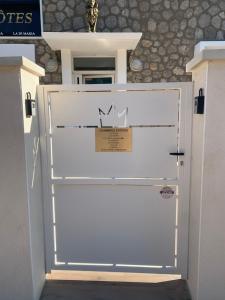 a white garage door with a sign on it at La CORSA CHAMBRE FAMILIALE DELUXE in Narbonne