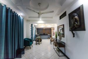 sala de estar con cortinas azules y comedor en Melvis' place, en Dar es Salaam