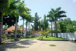 una casa con palmeras y una valla en Melvis' place, en Dar es Salaam