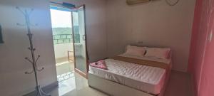 a small bedroom with a bed and a glass door at Hotel Greenvalley Residency in Punalūr