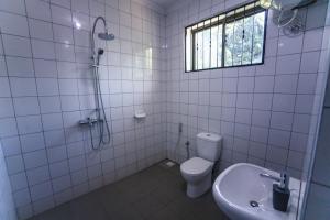 y baño con ducha, aseo y lavamanos. en Melvis' place, en Dar es Salaam