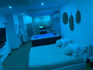 een blauwe kamer met een bed en een bad bij Superbe suite avec jacuzzi patio et sauna in La Ciotat