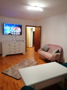 a living room with a couch and a tv on a wall at Acasă in Drobeta-Turnu Severin