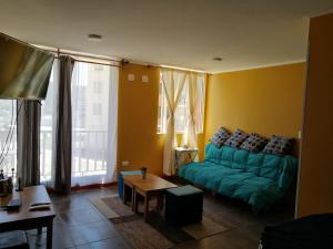 een woonkamer met een groene bank en een tafel bij DEPTO EN PUERTAS DEL MAR in La Serena