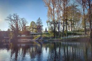 a body of water with trees and a white fence at O’Berges D’Astacus in Beloeil