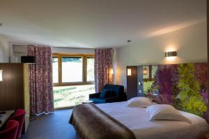 a hotel room with a large bed and a window at Hôtel L'Etang du Moulin By Céline in Bonnétage