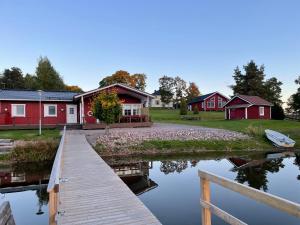 une maison avec un quai à côté d'une masse d'eau dans l'établissement Labbnäs Semesterhem, Radhuset, à Kemiönsaari
