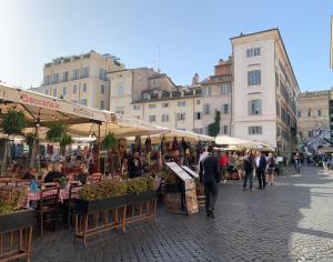 Un groupe de personnes se promenant autour d'un marché en plein air dans l'établissement Appartamento nel centro storico., à Rome