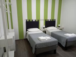 - 2 lits dans une chambre à rayures vertes et blanches dans l'établissement B&B KM 198 - Room&Breakfast, à Sorbara