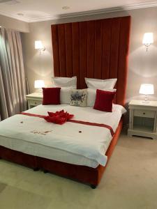 a bedroom with a large bed with red pillows at HOTEL CARPAT INN in Azuga