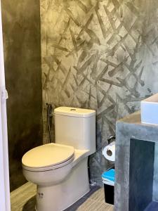 a bathroom with a toilet and a stone wall at Kohyao Non Bay in Ban Nai Wat