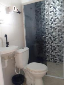 uma casa de banho com um WC, um lavatório e um chuveiro em Pousada Chalé Boracéia em Boraceia