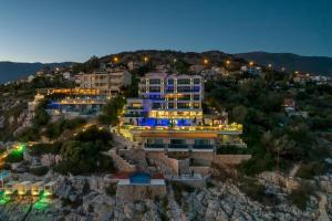 a building on top of a mountain at night at Meis Exclusive Hotel in Kaş