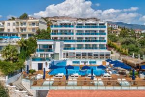 a hotel with a pool and chairs and umbrellas at Meis Exclusive Hotel in Kaş