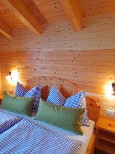 um quarto com uma cama com almofadas azuis e verdes em Haus Schwaiger em Bad Hofgastein