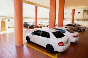 zwei weiße Autos auf einem Parkplatz geparkt in der Unterkunft La Rive Hotels & Suites in Dammam