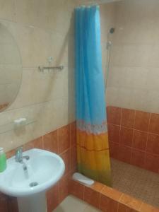 a bathroom with a sink and a rainbow shower curtain at Sevan Garden Complex in Sevan