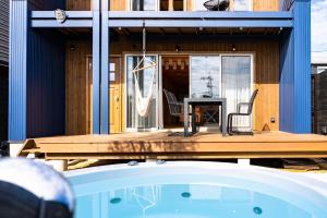 a house with a wooden deck next to a swimming pool at IZA近江舞子 in Minami-komatsu